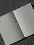 Load image into Gallery viewer, Open journal with lined pages on a textured surface