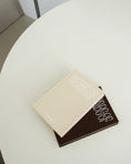 Bild in Galerie-Betrachter laden, Two books stacked on a round white table