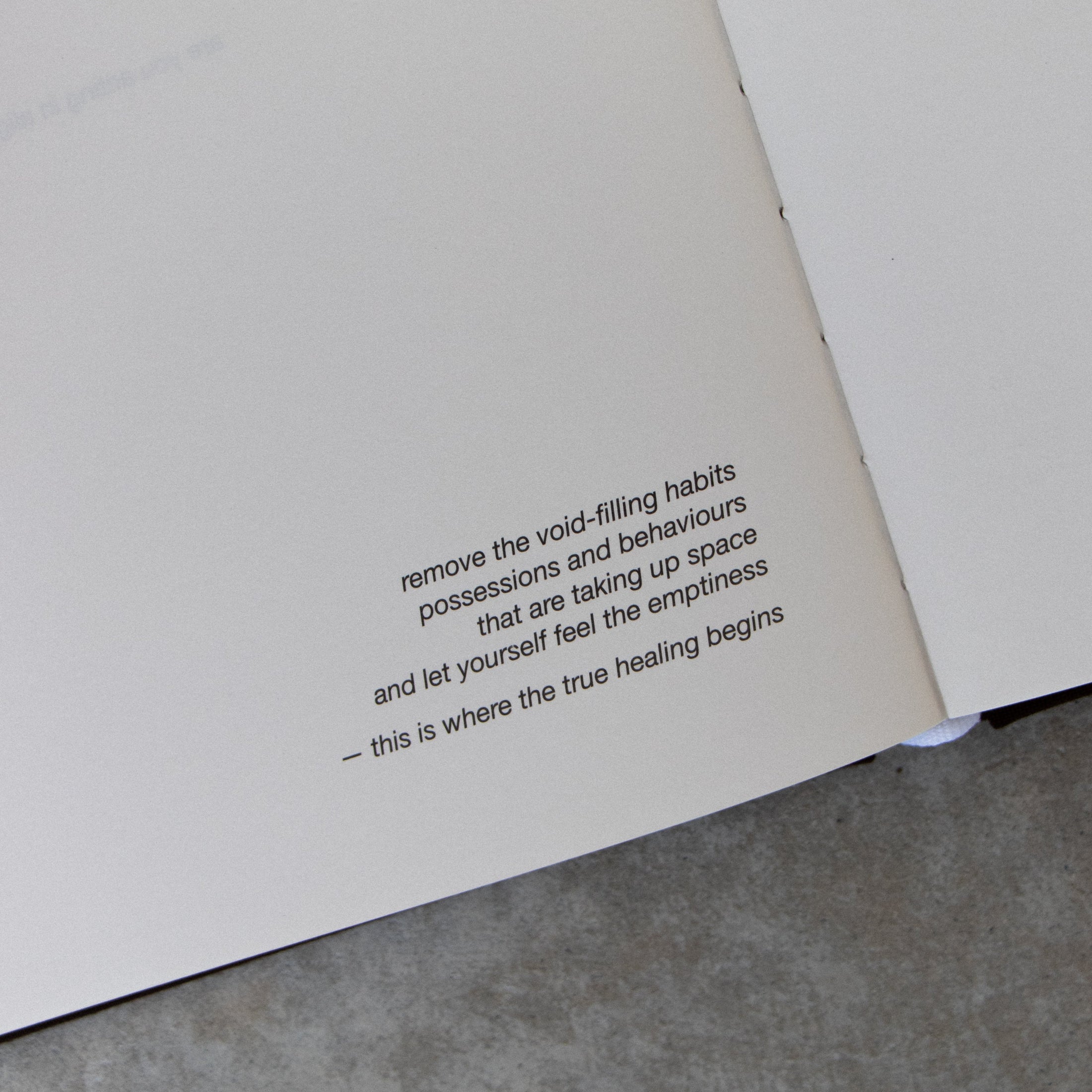 Open book with a philosophical quote on a concrete surface